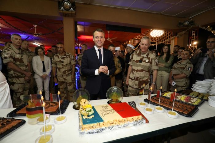 Le président français Emmanuel Macron devant un gâteau aux couleurs du drapeau français lors d'une réveillon avec des centaines de soldats français déployés au Niger sur une base de la force Barkhane, fête ses 40 ans, le 22 décembre 2017 à Niamey, Niger LUDOVIC MARIN (AFP)