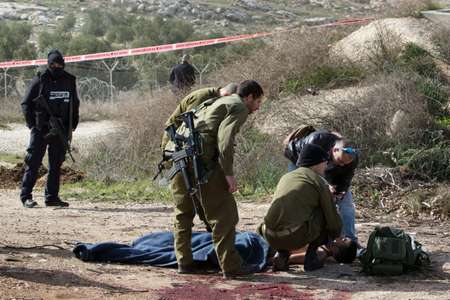 An injured Palestinian suspected attacker is treated by Israeli medic soldiers after he was shot following a stabbing attack on January 18, 2016 in the Tekoa settlement, south of Jerusalem ( Menahem Kahana (AFP) )