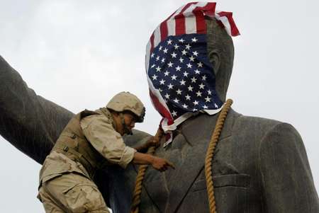 A US Marine covers the head of a statue of Iraqi President Saddam Hussein with the US flag on April 9, 2003 before it is toppled ( RAMZI HAIDAR (AFP/File) )