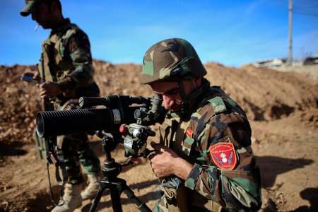 A Kurdish Peshmerga fighter uses a scope to measure the distance during fighting against Islamic State militants on November 8, 2014 in the Syrian besieged border town of Ain al-Arab - Ahmed Deeb (AFP/File) Ahmed Deeb (AFP/File)