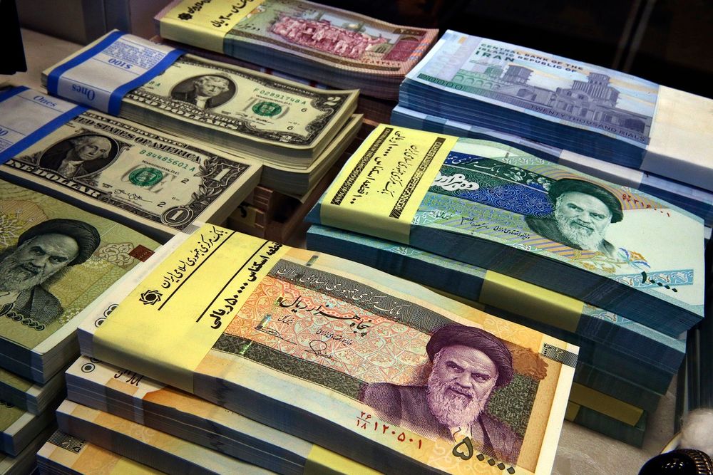 FILE - In this April 4, 2015 file photo, Iranian and U.S. banknotes are on display at a currency exchange shop in downtown Tehran, Iran.