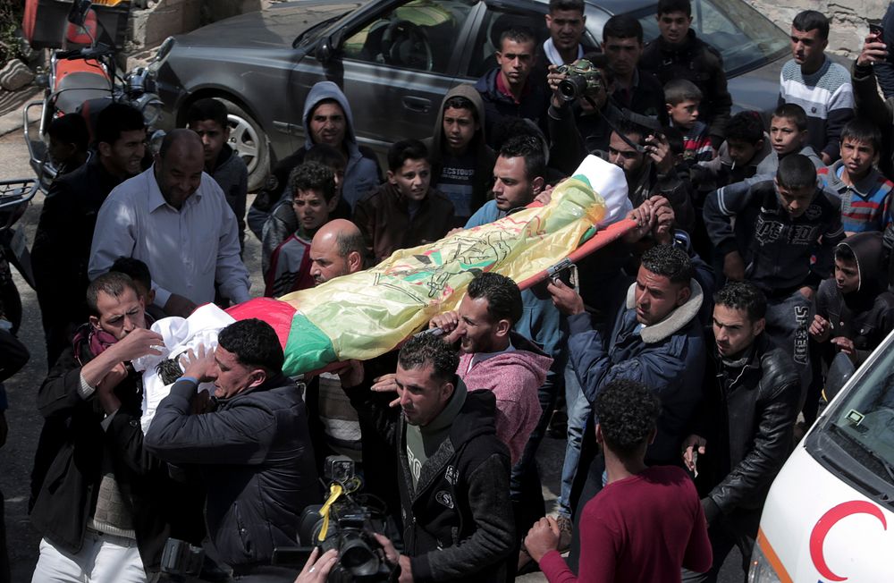 Relatives carry the body of farmer Amero Samor, 27, during his funeral, in front of his family house in Khan Younis, Gaza Strip, Friday, March 30, 2018.