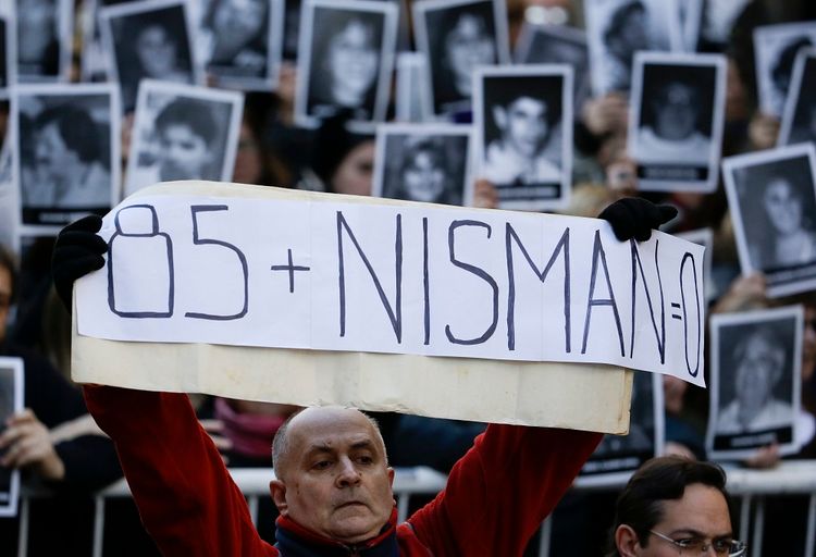 A man holds a sign that reads in Spanish: "Eighty-five plus Nisman equals zero" on the 22nd anniversary of the bombing of the AMIA Jewish center that killed 85 people in Buenos Aires, Argentina, Monday, July 18, 2016
