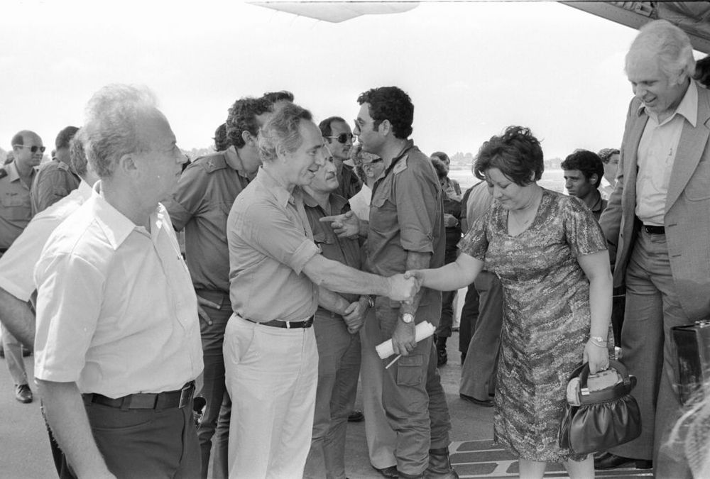 Then-defense minister Shimon Peres (c), along with former prime minister Yitzhak Rabin (l), meets the hostages released from Entebbe as they land in Israel on July 4, 1976