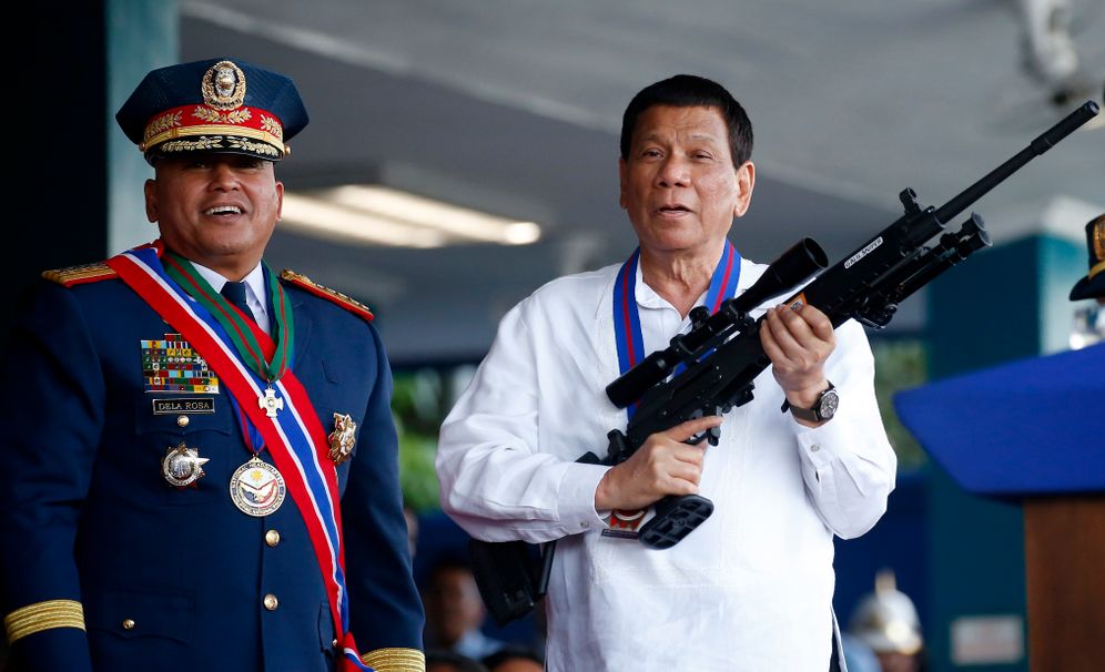 AP Photo/Bullit Marquez, File In this Thursday, April 19, 2018, file photo, Philippine President Rodrigo Duterte jokes to photographers as he holds an Israeli-made Galil rifle.