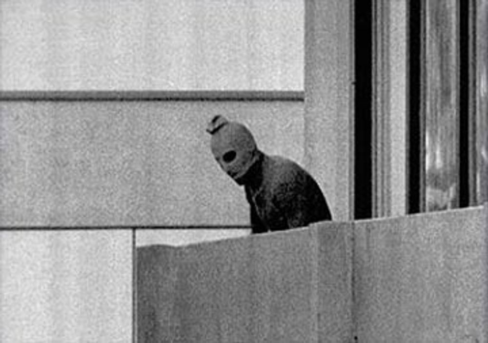 "Black September Palestiinian Terrorists Murder Members of the Israeli Olympic Team at their Quarters at the Munich Olympic Village." This is an iconic image showing one of the terrorists during the event known as the Munich Massacre, during the 1972 Summ