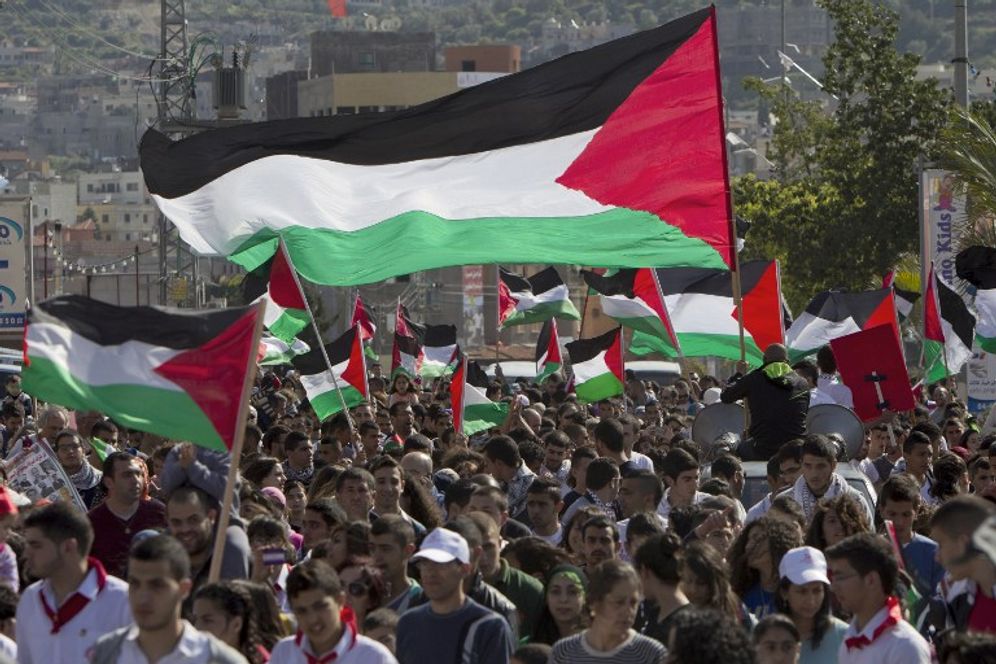 Arab Israelis wave Palestinian flags during a rally commemorating Land Day on March 30, 2014 in the northern Israeli town of Arrabe