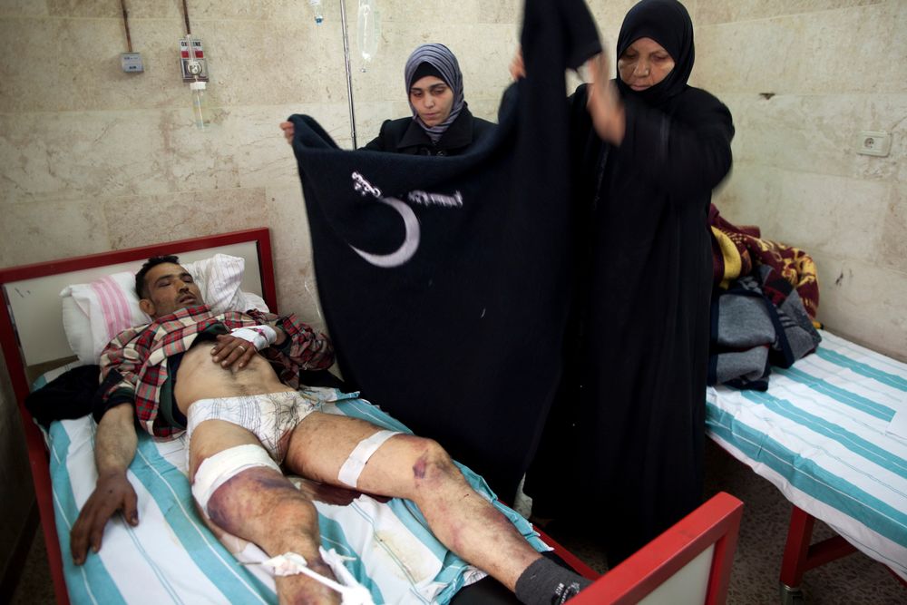 Relatives care for Mohammed Obed, who is recovering in a hospital after being captured and allegedly tortured by Syrian Army soldiers, in Idlib, north Syria, Wednesday, March 7, 2012.