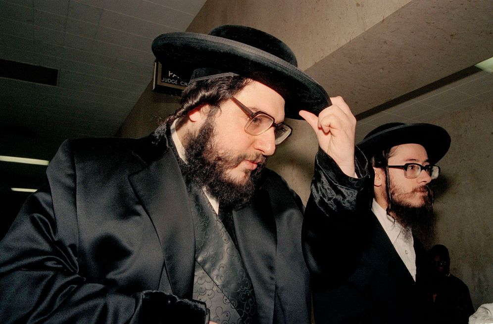 FILE - Rabbi Shlomo Hebrans adjusts his hat as he arrives at State Supreme Court in Brooklyn, N.Y., Oct. 3, 1994. Helbrans faces trial on charges of kidnapping teenager Shai Fhima, then 13, in 1992