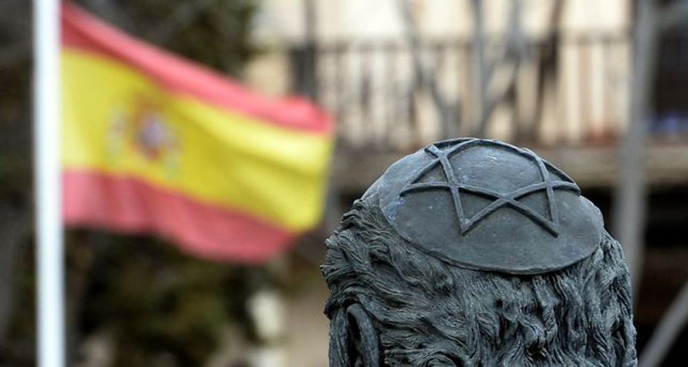 A picture taken on February 27, 2014 shows a sculpture of Samuel Halevi Abulafia and a Spanish flag near the "El Transito" synagogue and Sephardic Museum in Toledo, Spain, founded in 1357.