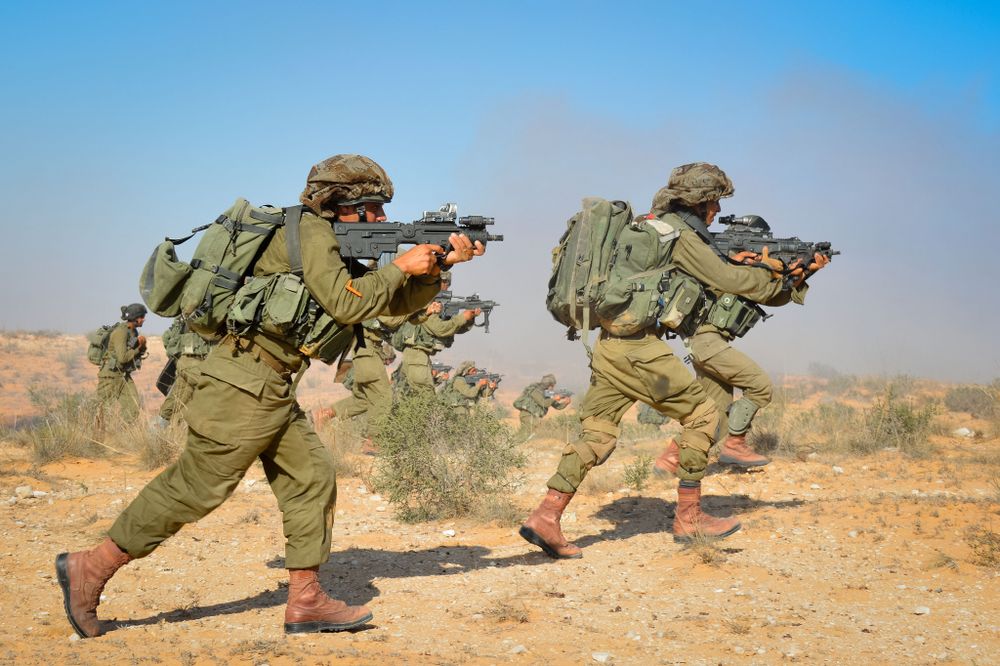 Israeli soldiers of the Desert Reconnaissance Battalion storm a hill during a company exercise, September 23, 2014