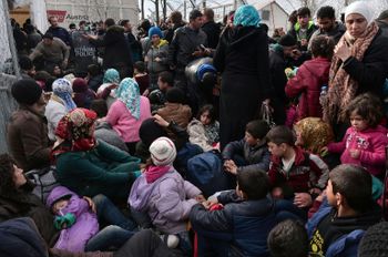 Des migrants attendent à la frontière entre la Grèce et la Macédoine, le 3 mars 2016 près d'Idomeni
