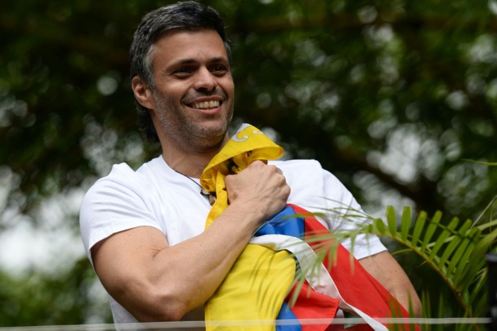 Venezuelan opposition leader Leopoldo Lopez holds a Venezuelan national flag against his chest, as he greets supporters gathering outside his house in Caracas after he was released from prison on July 8, 2017