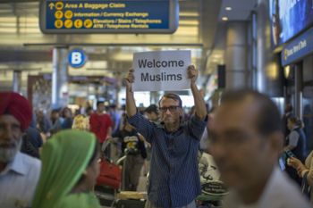 John Wider carries a welcome sign for Muslim travelers at Los Angeles International Airport on June 29, the day President Donald Trump's partial ban  on visitors and immigrants  from six mostly Muslim countries came into effect.