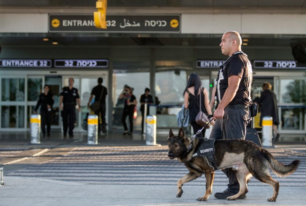 ضابط أمن يقود كلبًا أثناء قيامهم بدورية على مدخل مطار بن غوريون الدولي ، بالقرب من مدينة تل أبيب الساحلية على البحر المتوسط في إسرائيل ، 21 أغسطس ، 2014