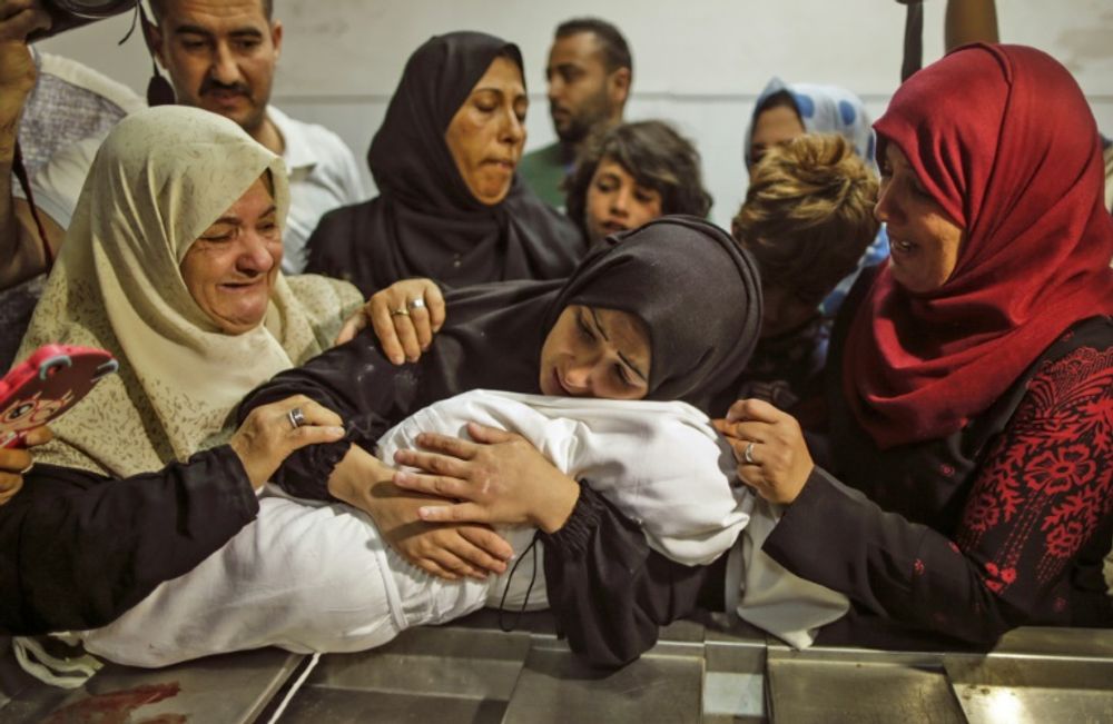 The body of a Palestinian baby who died of tear gas inhalation during clashes, according to Gaza's health ministry, is held by her mother at a Gaza City morgue on May 15, 2018