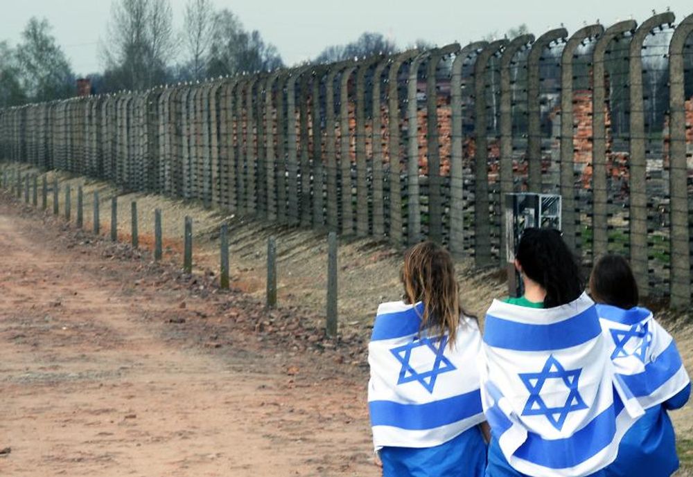 Des jeunes filles portant le drapeau israélien participent le 16 avril 2015 à la Marche des Vivants en hommage aux victimes de l'Holocauste sur le site de l'ancien camp nazi Auschwitz-Birkenau