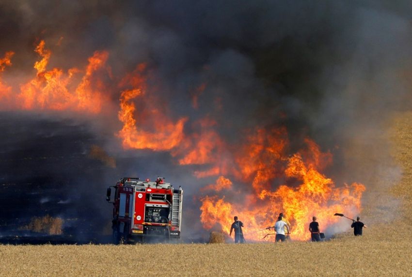 Des pompiers israéliens tentent d'éteindre l'incendie d'un champs proche de à la frontière avec la bande de Gaza, le 15 mai 2018