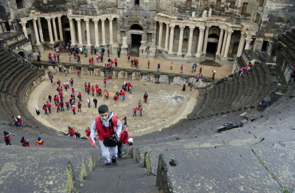De jeunes Syriens visitent le théâtre romain de Bosra, dans le sud du pays, lors d'une visite organisée sous le patronage du ministère du tourisme, dans ce pays ravagé par une guerre qui dure depuis plus de sept ans. Photo du 23 novembre 2018