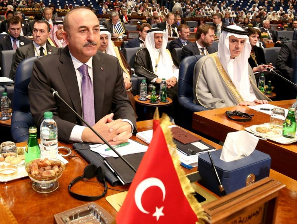 Turkish Foreign Minister Mevlut Cavusoglu (L) and his Saudi counterpart Adel al-Jubeir attend the second day of an international conference for the reconstruction of Iraq, in Kuwait City, on February 14, 2018