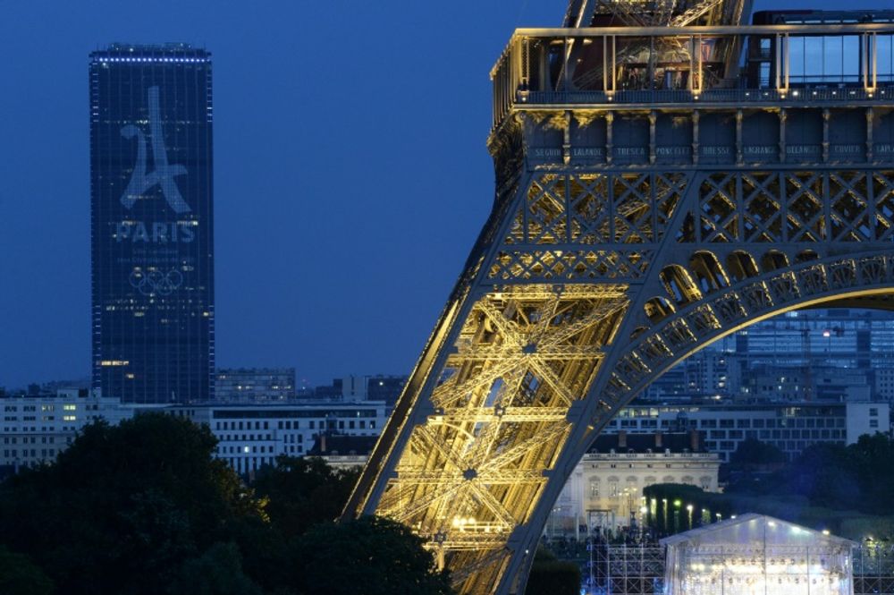 The Tour Montparnasse with the logo for the logo for the Paris 2024 Olympic bid is seen near the Eiffel Tower in Paris.