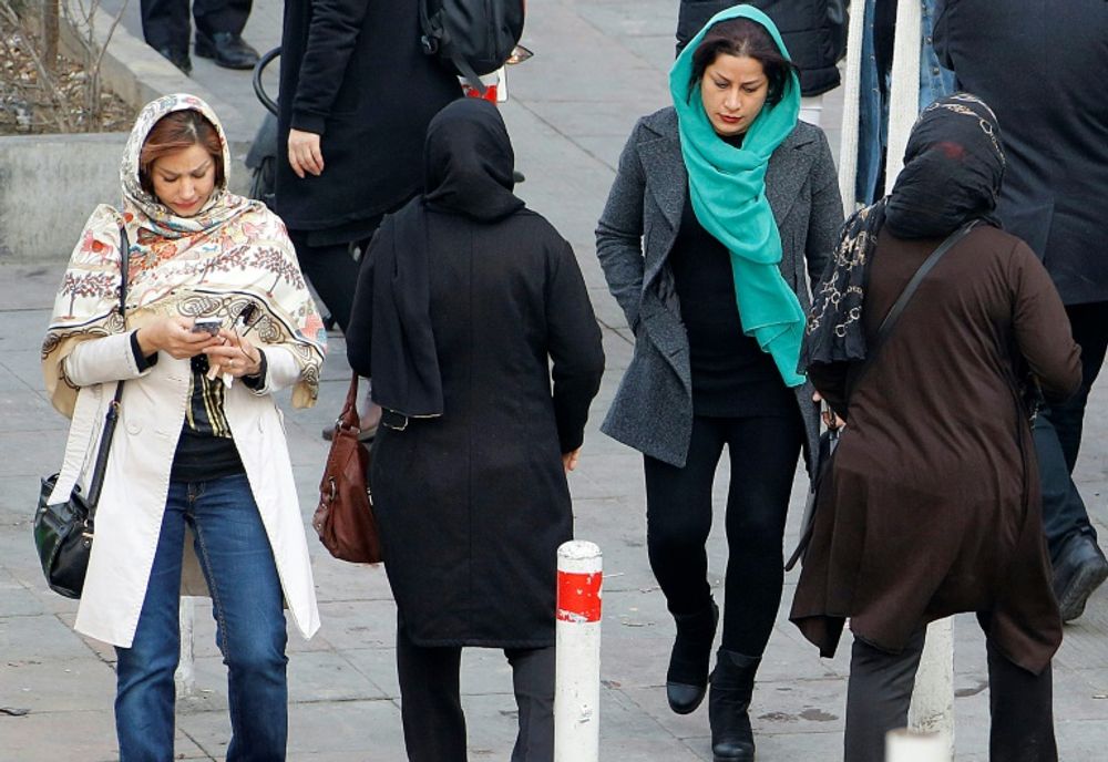 Iranian women wearing hijab walk down a street in the capital Tehran