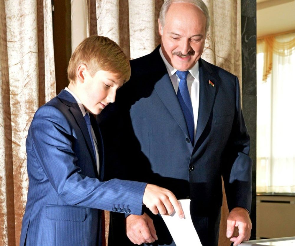 Belarus' President Alexander Lukashenko looks on as his son casts his ballot during presidential elections, at a polling station in Minsk, on October 11, 2015