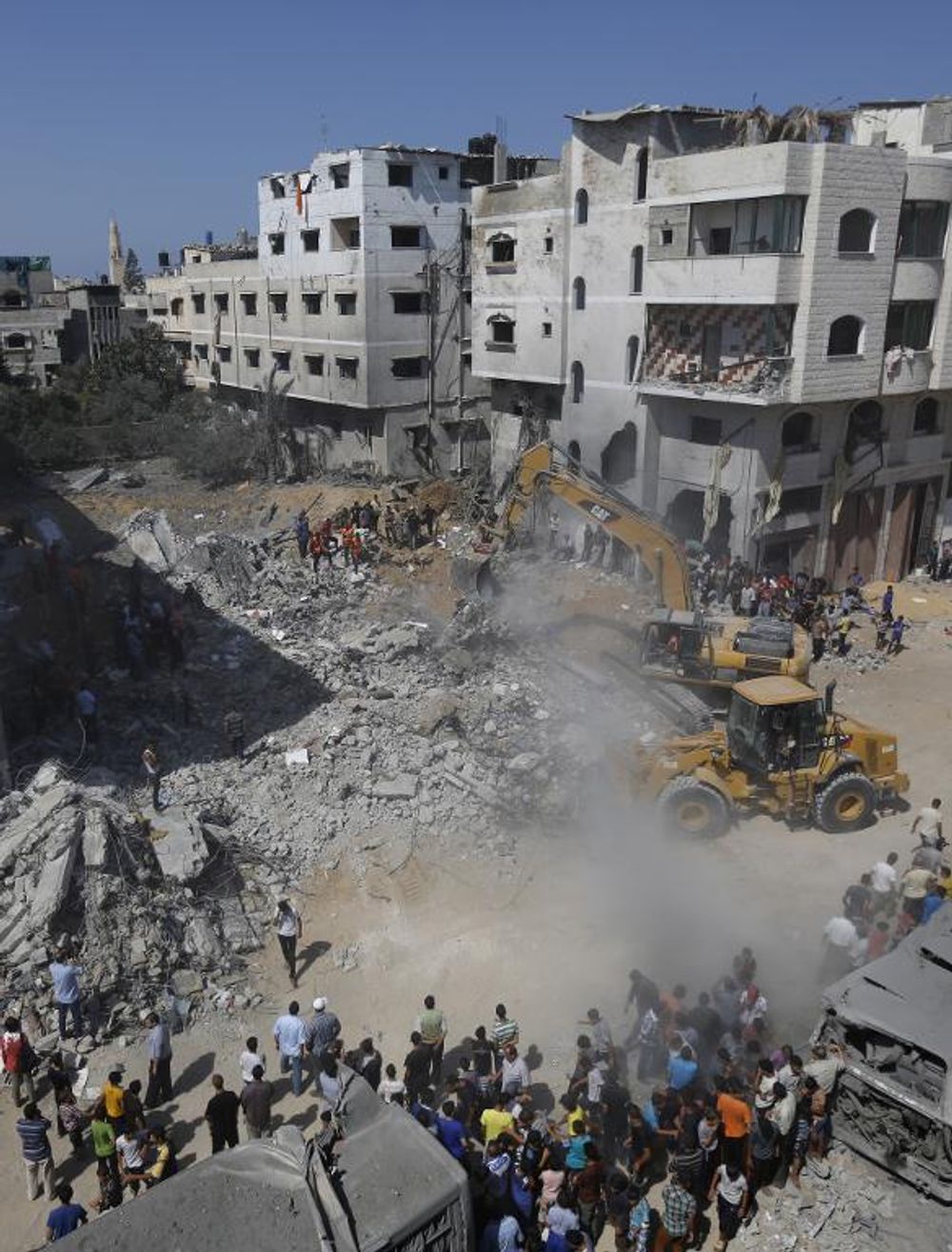 A digger removes on August 20, 2014, the cement and debris of a home destroyed the night before in an Israeli air strike on Gaza City's Sheikh Radwan neighbourhood