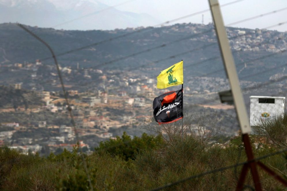 A flag of Lebanon's Hezbollah Shiite movement and a religious flag reading "al-Hussein" fly on the border with Israel