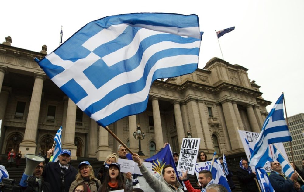 Protesters wave the Greek flag as they shout "Oxi" (No) during the "Melbourne stands with Greece" solidarity rally outside Parliament House in Melbourne on July 4, 2015