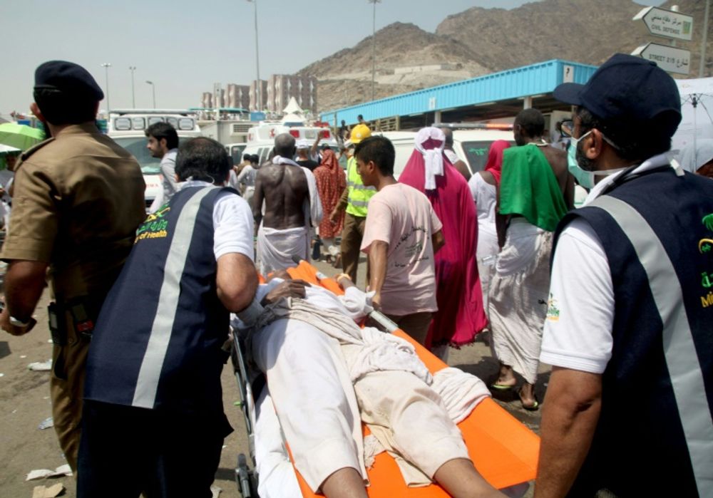 Saudi emergency personnel carry a hajj pilgim on a stretcher after the deadly stampede in Mina, near the holy city of Mecca on September 24, 2015