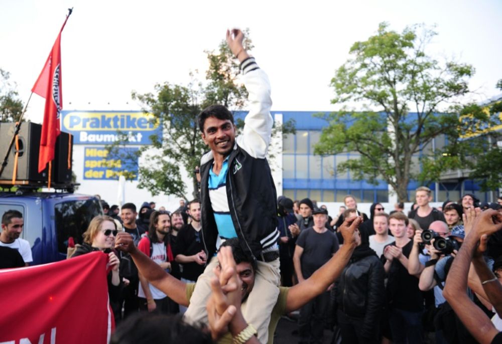 Des réfugiés font la fête avec des manifestants anti-racistes à Heidenau le 29 août 2015