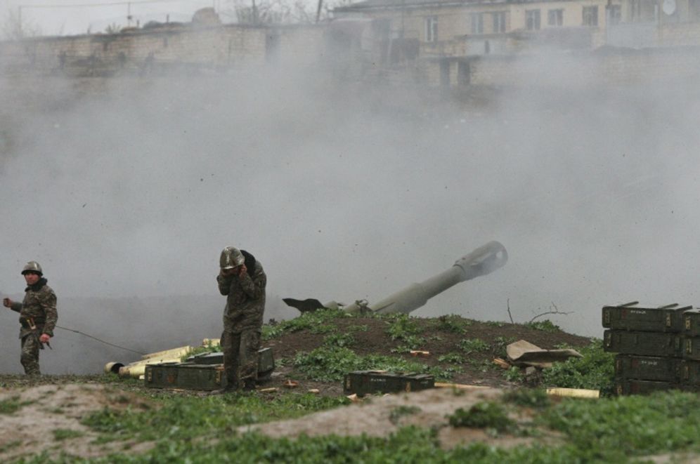 Armenian servicemen of the self-defense army of Nagorno-Karabakh fire an artillery shell towards Azeri forces from their positions in the town of Martakert on April 3, 2016