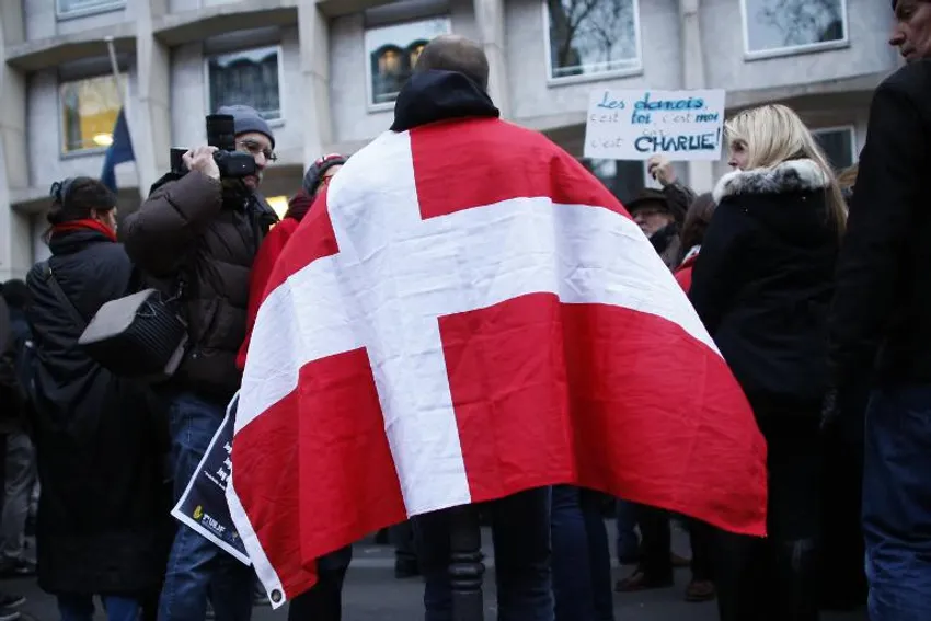 A protester holds a Danish flag during a demonstration outside the Embassy of Denmark in Paris, France, on February 15, 2015, a day after a gunman shot two people dead in Copenhagen