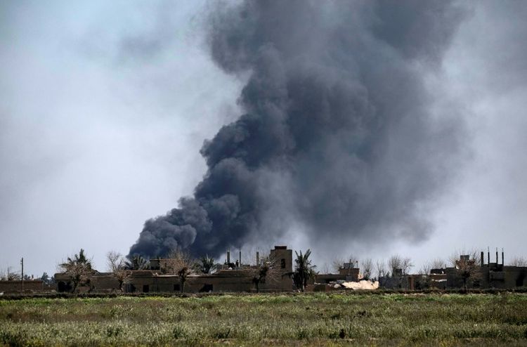 Black smoke billows from the village of Baghouz near Syria's border with Iraq, undated.