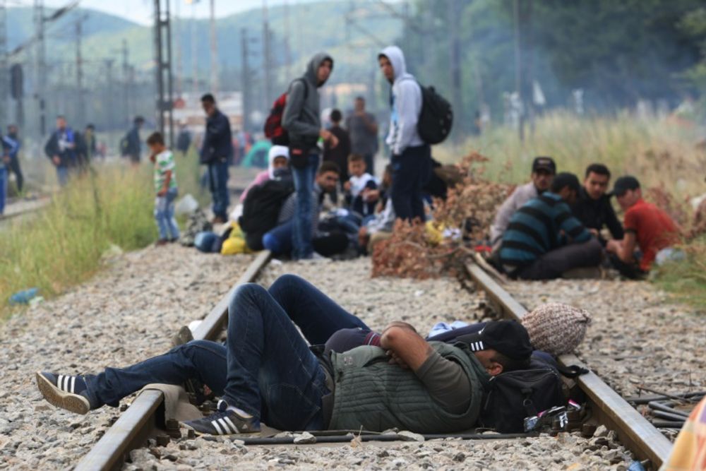 Des migrants se reposent avant de traverser la frontière entre la Grèce et la Macédoine, près de la ville d'Idomeni, dans le nord de la Grèce, le 21 août 2015