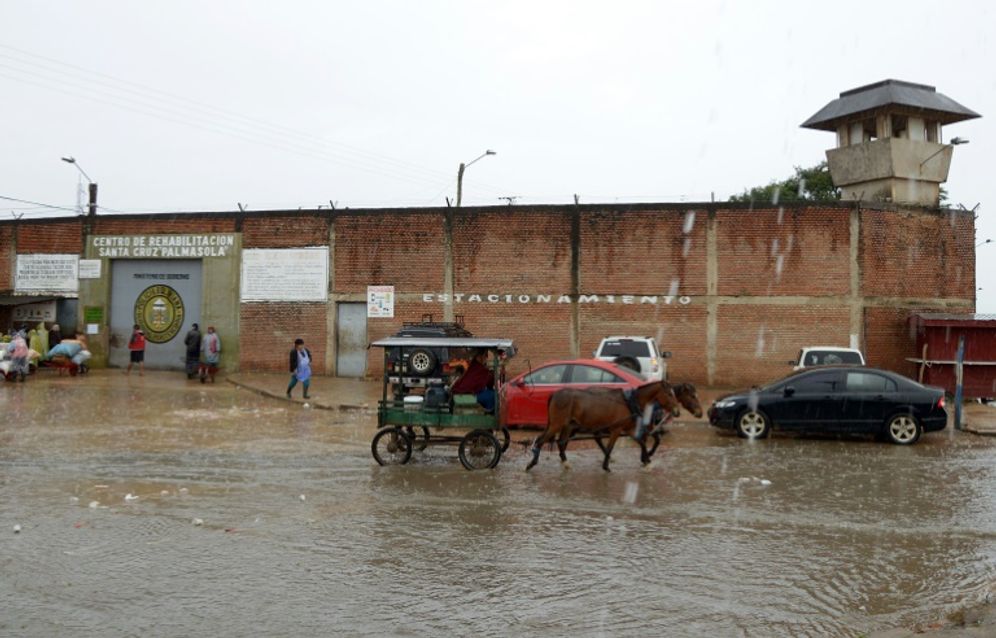 A woman passes by with her carriage in front of the Santa Cruz Rehabilitation Center "Palmasola" in Santa Cruz, Bolivia, on July 8, 2015