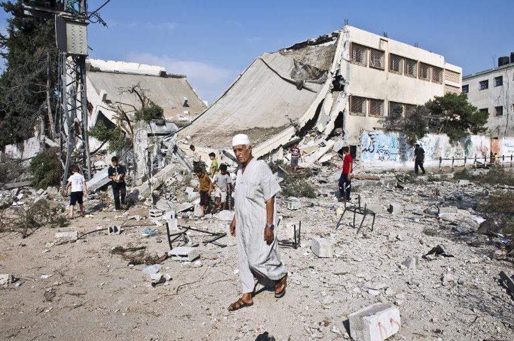 Un Palestinien marche devant les ruines d'une école détruite par les bombardements à Gaza le 26 août 2014