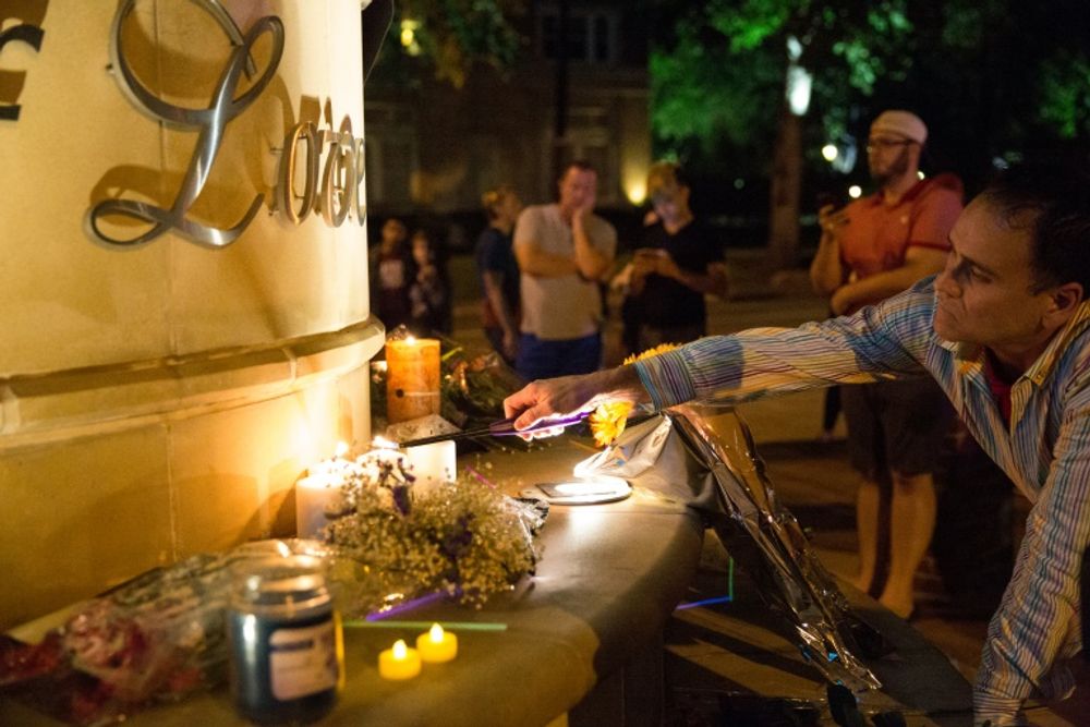 Mourners light candles at the Legacy of Love statue during a vigil in Dallas, Texas, on June 12, 2016, for victims of the attack at Orlando's Pulse Nightclub in Orlando, Florida