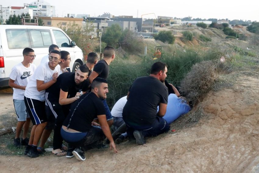 Des Israéliens se mettent à couvert à Sdérot, lors de tirs de roquettes depuis la bande de Gaza voisine, le 13 novembre 2018
