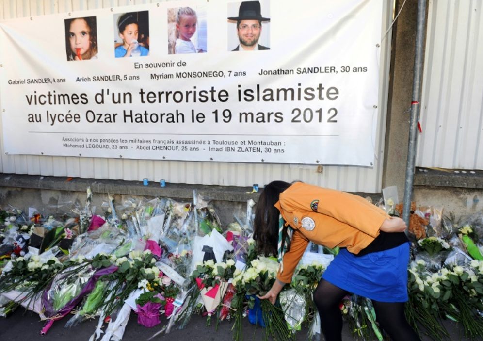 A bunch of white roses is laid on March 25, 2012 in Toulouse under a banner paying tribute to victims of jihadist Mohamed Merah who killed three children and a teacher at a Jewish school. The trial of his brother Abdelkader Merah begins October 2