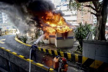 رجال الاطفاء يحاولون اخماد النار في كشك اضرم متظاهرون النار فيه في كراكاس في 20 تموز/يوليو 2017