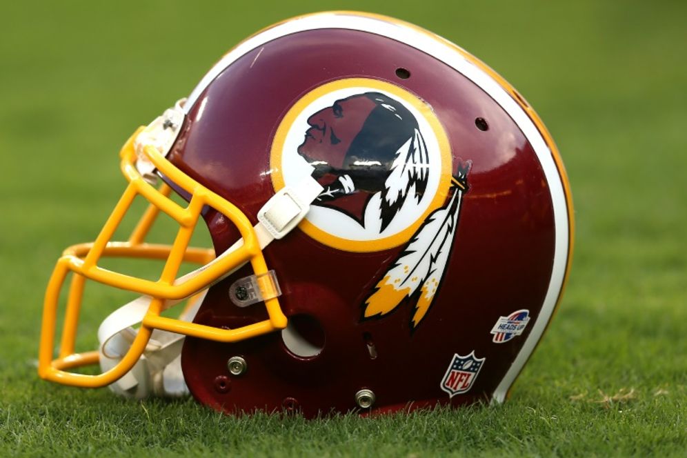 A Washington Redskins helmet bearing the team logo rests on a football field