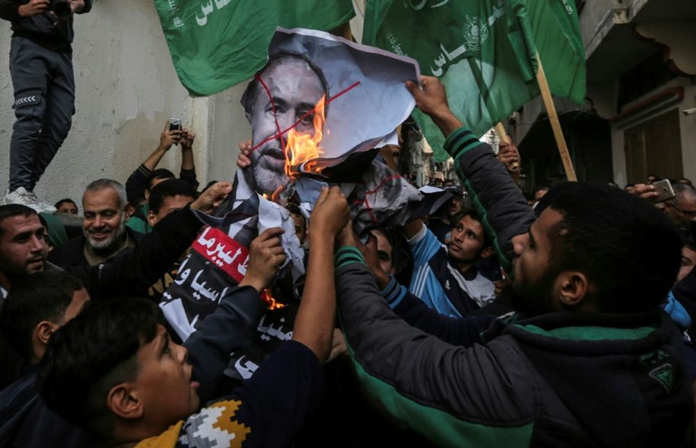 Palestinian demonstrators burn pictures of Israeli Defence Minister Avigdor Lieberman who has  resigned in protest at a Gaza ceasefire hailed as a victory by the territory's Islamist rulers Hamas