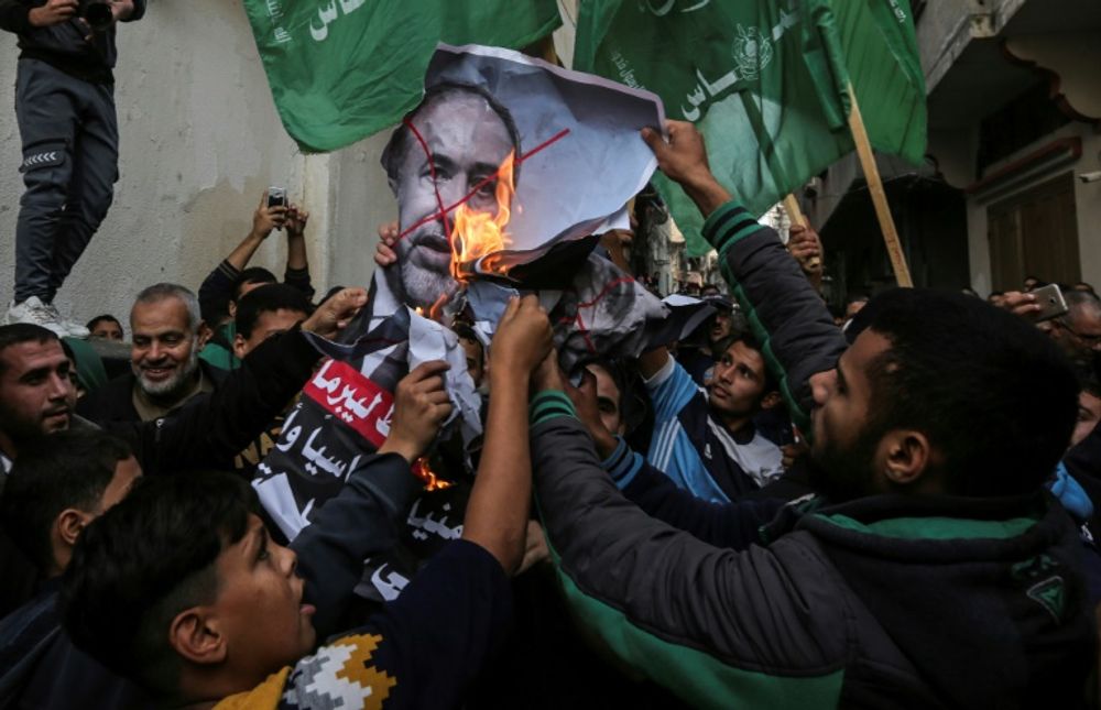 Palestinian demonstrators burn pictures of Israeli Defence Minister Avigdor Lieberman who has resigned in protest at a Gaza ceasefire hailed as a victory by the territory's Islamist rulers Hamas