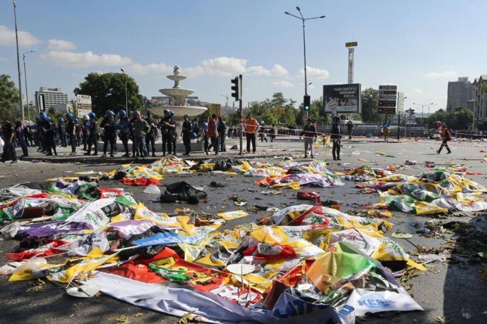 Des policiers autour des corps de victimes, recouverts de drapeaux, du double attentat qui a fait au moins 86 morts à Ankara en Turquie, le 10 octobre 2015