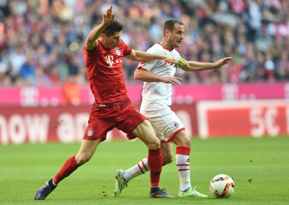 Bayern Munich's Polish striker Robert Lewandowski (L) and Cologne's midfielder Matthias Lehmann vies for the ball with during the German first division Bundesliga football match on October 24, 2015 in Munich, southern Germany