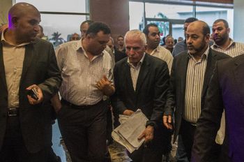 Le chef de la délégation palestinienne Azzam al-Ahmed (centre) et le vice-président du Hamas Musa Abu Marzuk (droite) arrivent à leur hôtel au Caire le 13 août 2014
