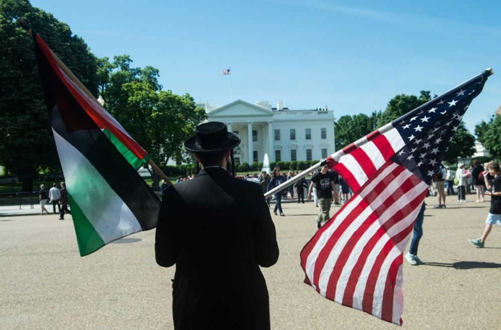An Orthodox Jew holds an American flag and a Palestinian flag in front of the White House in Washington, May 3, 2017.