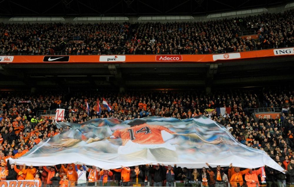 Supporters display a large banner during a standing ovation in honour of late Dutch football legend Johann Cruyff during a pause in the 14th minute of the friendly football match on March 25, 2016, in Amsterdam